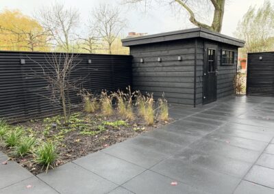 moderne tuin met zwarte schutting en berging hoveniersbedrijf Neeleman Krimpen a/d IJssel